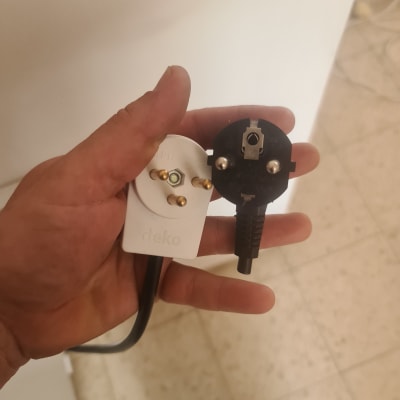 יד מחזיקה תקע חשמלי לבן ושחור