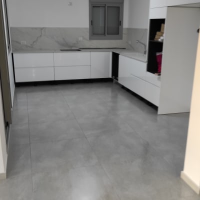 מטבח נקי עם רצפה מבריקה וארונות לבנים