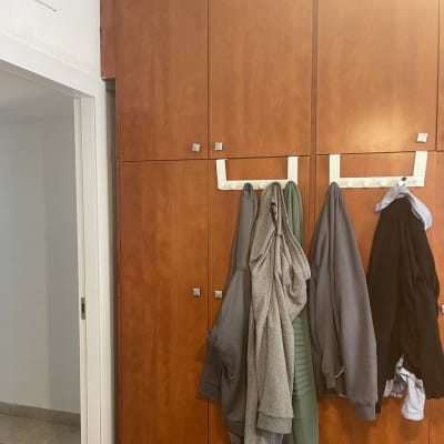 ארון עץ עם בגדים תלויים על מתלה