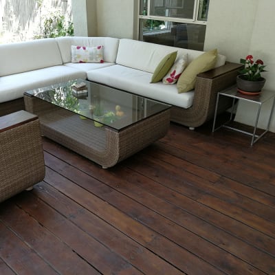 רצפת עץ כהה עם שולחן זכוכית וספה פינתית