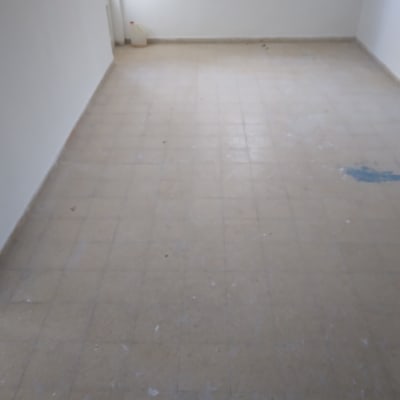 רצפה מלוכלכת עם כתמים, מיכל פלסטיק בפינה