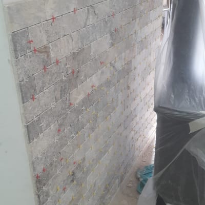 קיר עם אריחים ומרווחים צבעוניים בתהליך שיפוץ