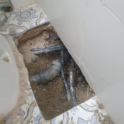 צינור פלסטיק חשוף בתוך חפירה ברצפה