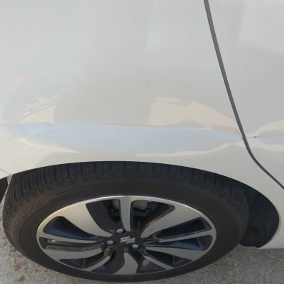 פגוש רכב לבן עם שריטה מעל הגלגל האחורי