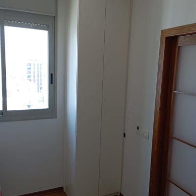 ארון עץ לבן בפינת חדר ליד חלון