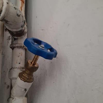 שסתום מים עם ידית כחולה על צינור