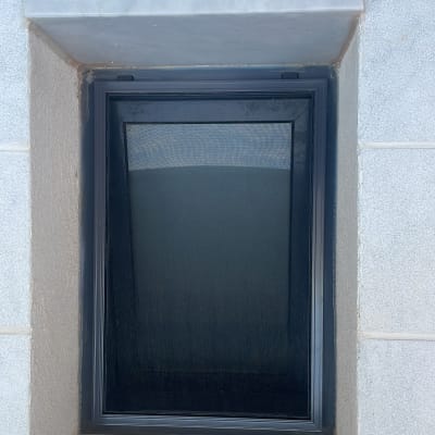 חלון אלומיניום עם מסגרת כהה בקיר בטון