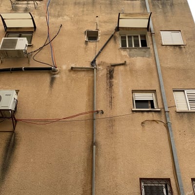 צינורות וכבלים על קיר בניין גבוה