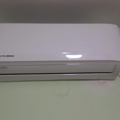 מזגן קיר לבן מותקן על קיר ירוק