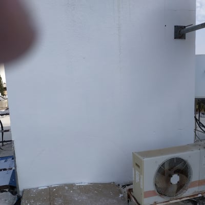 קיר צבוע בלבן עם סימני צבע על הרצפה