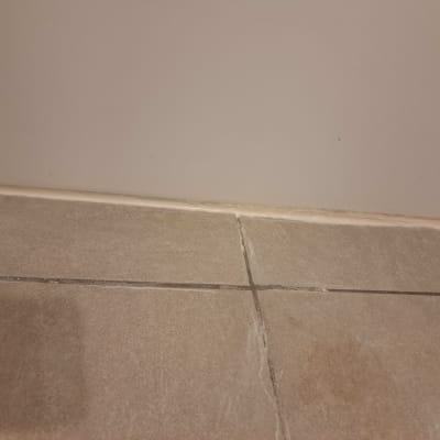 רובה בין אריחי קרמיקה על רצפה וקיר