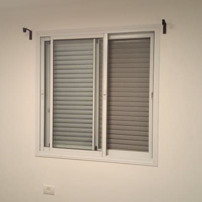 חלון עם תריסים סגורים על קיר לבן