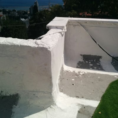 איטום גג עם חומר לבן על פינות וקירות