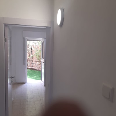 מנורה עגולה דולקת על קיר מסדרון