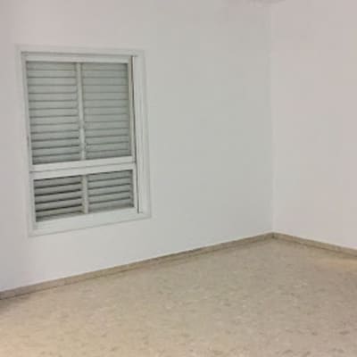 חדר ריק עם קירות לבנים ותאורה עליונה