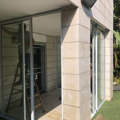 אדם עובד על מסגרת אלומיניום של חלון זכוכית