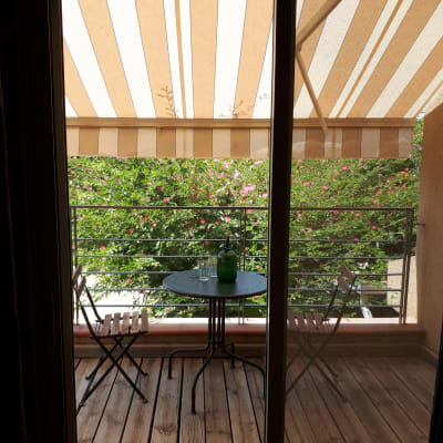 סוכך פסים לבן וחום מעל מרפסת עץ