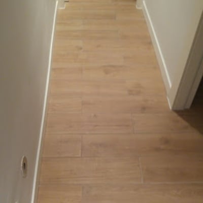 רצפת עץ חדשה במסדרון עם קירות לבנים