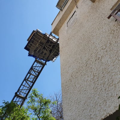 מנוף משא מעביר חפצים לקומה גבוהה בבניין