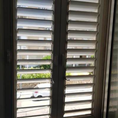 תריסים לבנים פתוחים בחלון כפול