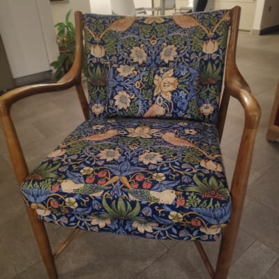 כיסא מרופד בבד פרחוני צבעוני עם מסגרת עץ