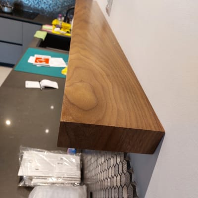 מדף עץ מותקן על קיר לבן