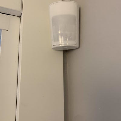 חיישן תנועה לבן מותקן על קיר פנימי