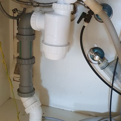 צנרת פלסטיק מתחת לכיור עם מחברים וברזים