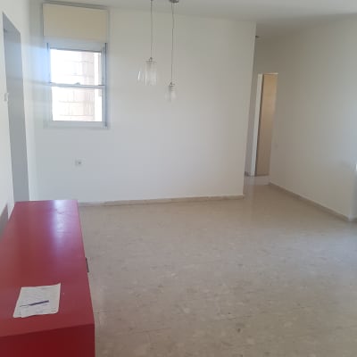 חדר עם קירות לבנים ורצפת שיש