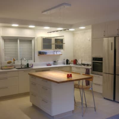 מטבח משופץ עם אי מרכזי ותאורה מודרנית