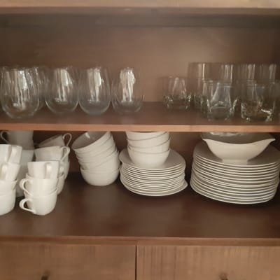 כוסות זכוכית, ספלים וצלחות מסודרים בארון מטבח