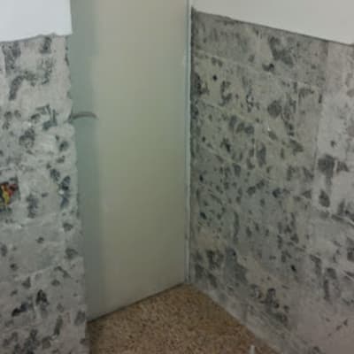 קיר בטון חשוף עם אריחים חלקיים בשיפוץ