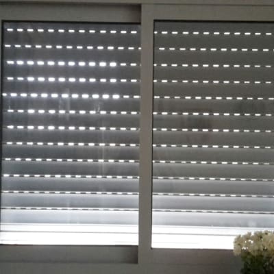 תריסים אפורים סגורים עם חריצים לאור