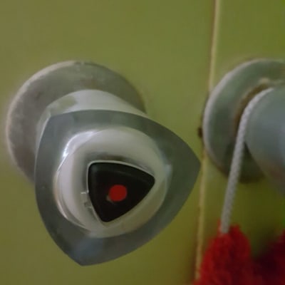 ברז מים עם ידית משולשת על קיר ירוק