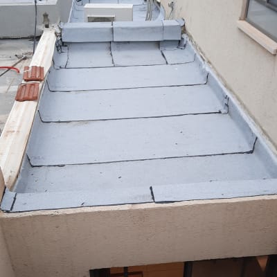 גג אטום ביריעות ביטומניות אפורות עם חיבורים שחורים