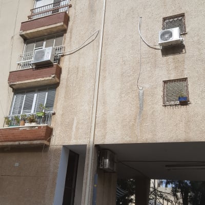 בניין עם מרפסות ומזגנים על הקיר החיצוני