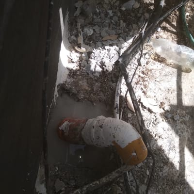 צינור כתום עם איטום לבן בתוך בטון שבור