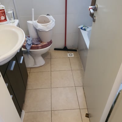 חדר אמבטיה עם רצפה רטובה ומגב