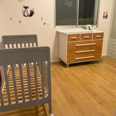 רצפת פרקט עץ בחדר ילדים עם מיטת תינוק