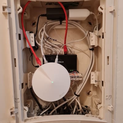 ארון תקשורת עם כבלים ומכשיר TP-Link עגול