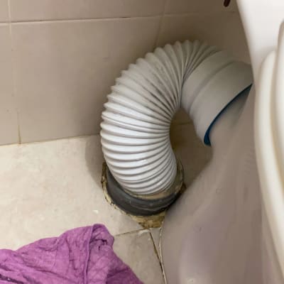 צינור גמיש מחובר לאסלה בחדר אמבטיה