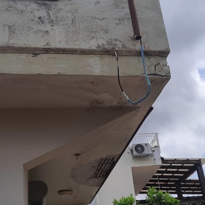 קיר חיצוני עם סדקים וצינור חשוף