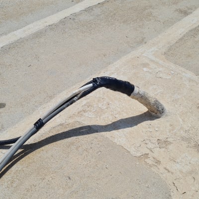 כבל חשמל עטוף בבידוד שחור על גג בטון