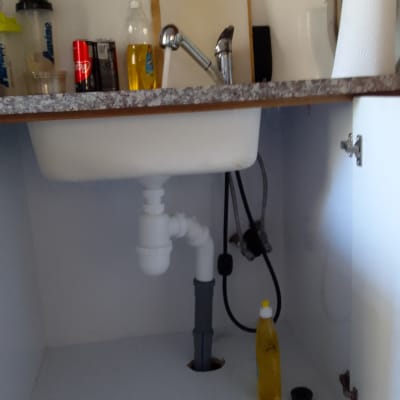 כיור מטבח עם צנרת מתחת לארון