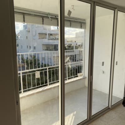 דלתות זכוכית גדולות עם מסגרת מתכת במרפסת