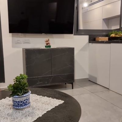 חדר מגורים עם טלוויזיה וארון עץ כהה