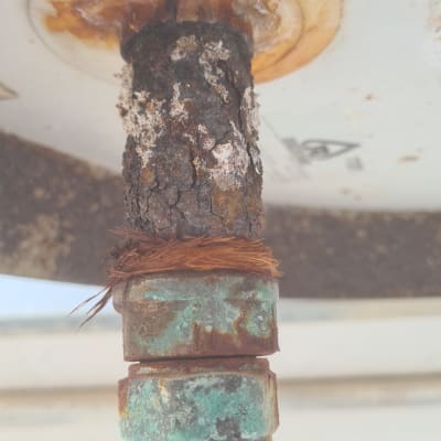 צינור חלוד עם חיבור מתכת ירוק על דוד שמש