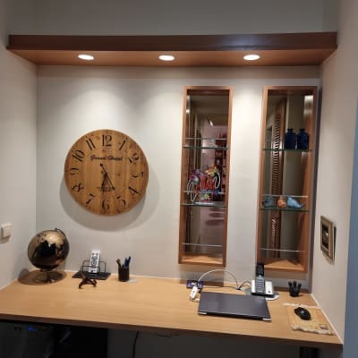 שעון עץ עגול על קיר מעל שולחן עץ