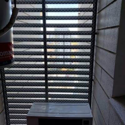 רשת מתכת על חלון למניעת כניסת יונים