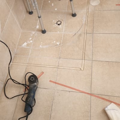 כלי עבודה על רצפת אריחים עם קווי איטום